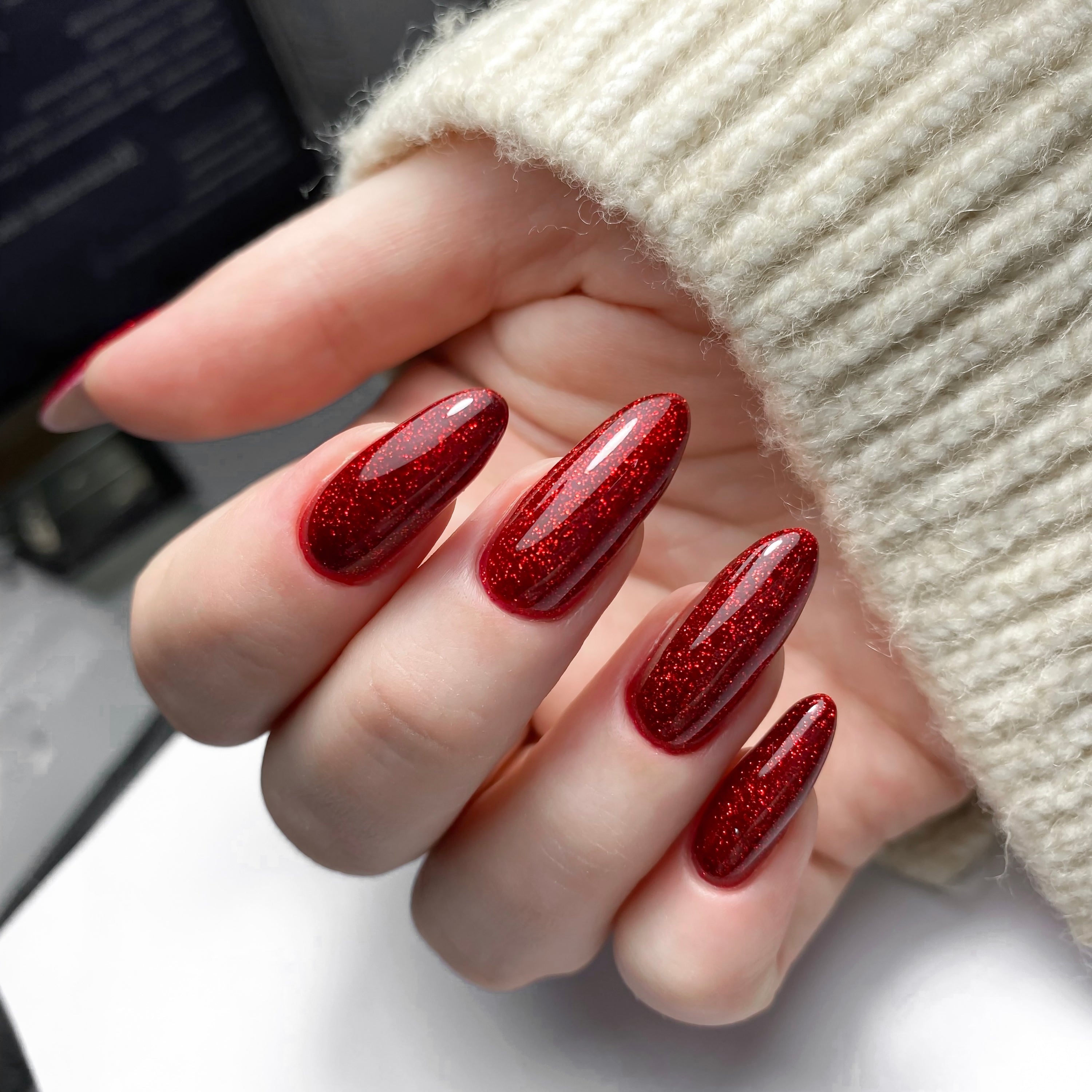 Close-up of manicured hands showcasing Nails with glossy red polish.