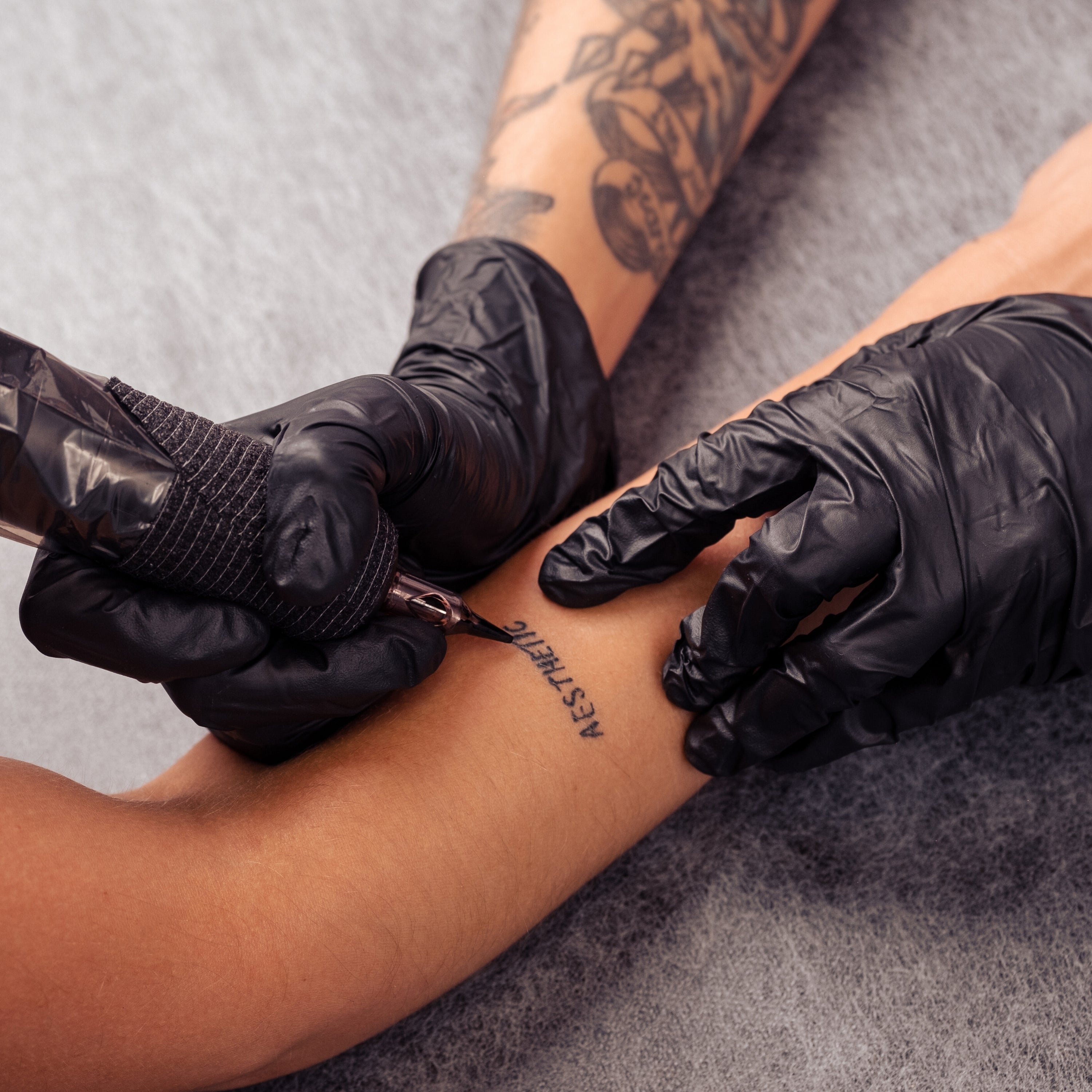Professional Tattooing Supplies including needles and machine on a workstation.