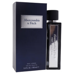 First Instinct Blue glass bottle under soft lighting communicates premium masculine scent.