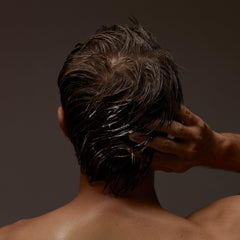 Aesop Conditioner hair-application scene shows even smoothing on damp strands