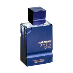 Al Haramain Amber Oud Dubai Night bottle with glass illustrates lasting sillage in use.