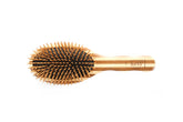 Bass Green Brush close-up shows bamboo pins for gentle detangling and sustainability.