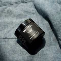 Brickell Strong Hold Pomade hands applying for easy, controllable styling.