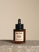 Bur Bur Growing Season Oil bottle closeup showcases nourishing formula for healthier follicles.
