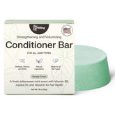 The Earthling Co. conditioner bar in hand demonstrates solid form for easy travel and mess-free conditioning.