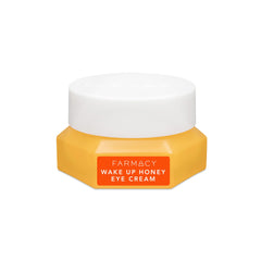 Farmacy Wake Up Honey Eye Cream tube applying a light layer to brighten under eyes.