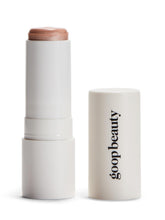 Goop Beauty Glow Skin Highlighter Stick texture closeup shows pearlescent glow on skin.
