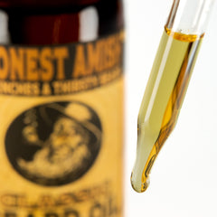 Honest Amish Classic Beard Oil bottle pour demonstrates easy-to-use application for grooming.