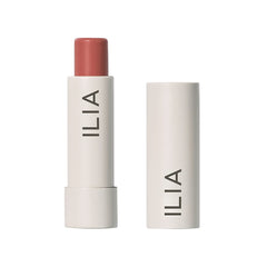 ILIA Balmy Tint Hold Me lip balm close-up showing warm peachy nude color and moisture.