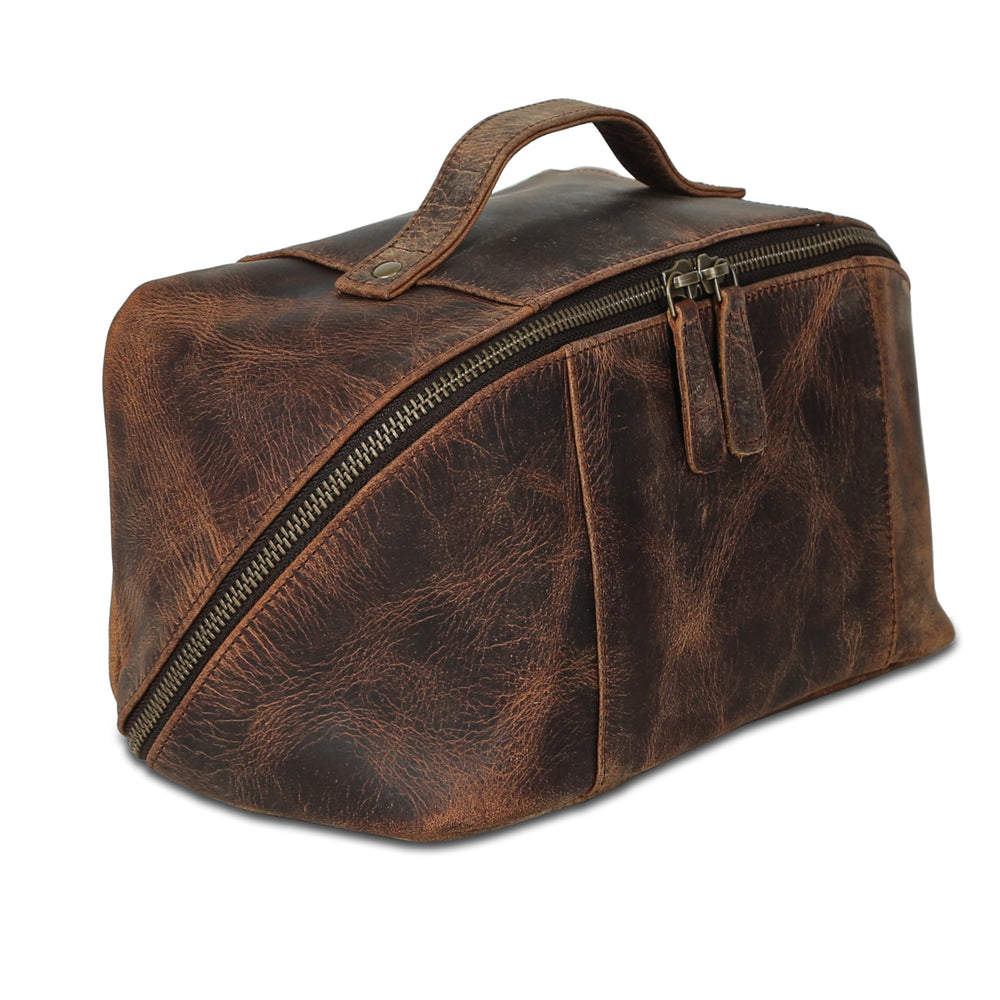 KomalC luxury leather toiletry bag closeup shows premium grain and craftsmanship for durable travel.