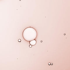 KORA Organics Turmeric Glow Drops texture swirl shows smooth, hydrated skin finish.