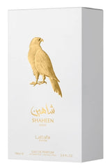 Lattafa Pride Shaheen Gold bottle on table emphasizes its unisex appeal for daily wear.