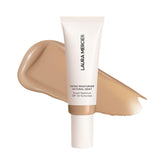 Laura Mercier tinted moisturizer sand bottle close-up shows radiant hydration and dewy finish.