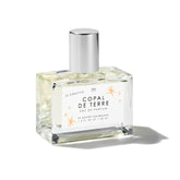 Le Monde Gourmand Copal de Terre bottle close-up with amber glow for daily fragrance ritual.