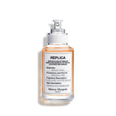 Maison Margiela Replica Autumn Vibes bottle on a warm surface, signaling timeless elegance for daily fragrance routines.