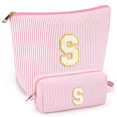 Mibasies two-piece initial makeup bag in light pink opens to reveal organized compartments for travel cosmetics.