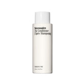 Nécessaire The Conditioner fragrance-free bottle foreground, signaling fragrance-free hydration for scalp and hair.
