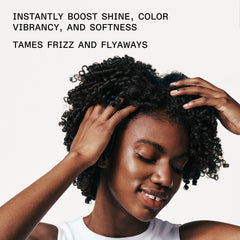 stylist applying Olaplex No.7 to damp hair mid-lengths demonstrating frizz control and manageability