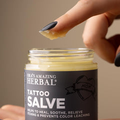 Ora's Amazing Herbal Tattoo Salve in hand shows easy application for aftercare.