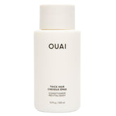 OUAI Thick Hair Conditioner bottle pouring for detangling and frizz control.