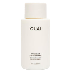 OUAI Thick Hair Conditioner bottle pouring for detangling and frizz control.