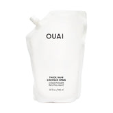 OUAI Thick Hair Conditioner refill bottle closeup highlighting hydrating formula for strands