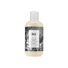 R+Co Bel Air shampoo bottle demonstrates smoothing formula for a sleek, frizz-controlled finish.