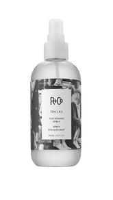 R+Co Dallas thickening spray bottle close-up boosts volume for all hair lengths.