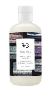 R+Co Television Perfect Hair Shampoo bottle on countertop for smooth, camera-ready shine.