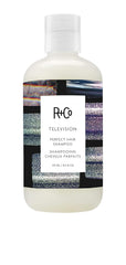 R+Co Television Perfect Hair Shampoo bottle on countertop for smooth, camera-ready shine.