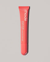 Rhode Peach Pit lip tint application swatch with clear tint and glossy finish.