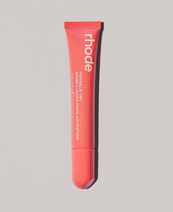 Rhode Peach Pit lip tint application swatch with clear tint and glossy finish.