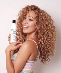 Rizos Curls Hydrating Shampoo pump action demonstrates easy, mess-free application during shower routines.