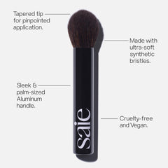 Saie The Fluffy Brush palm-handle view shows travel-friendly design for easy on-the-go touch-ups.