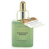Sand + Fog Pistachio Dream bottle on mint-green glass for luxurious vanity presentation.