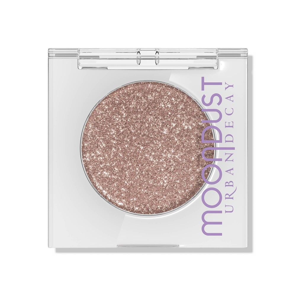 Urban Decay Moondust Space Cowboy swatch on arm reveals champagne-gold sparkle with lasting shine.