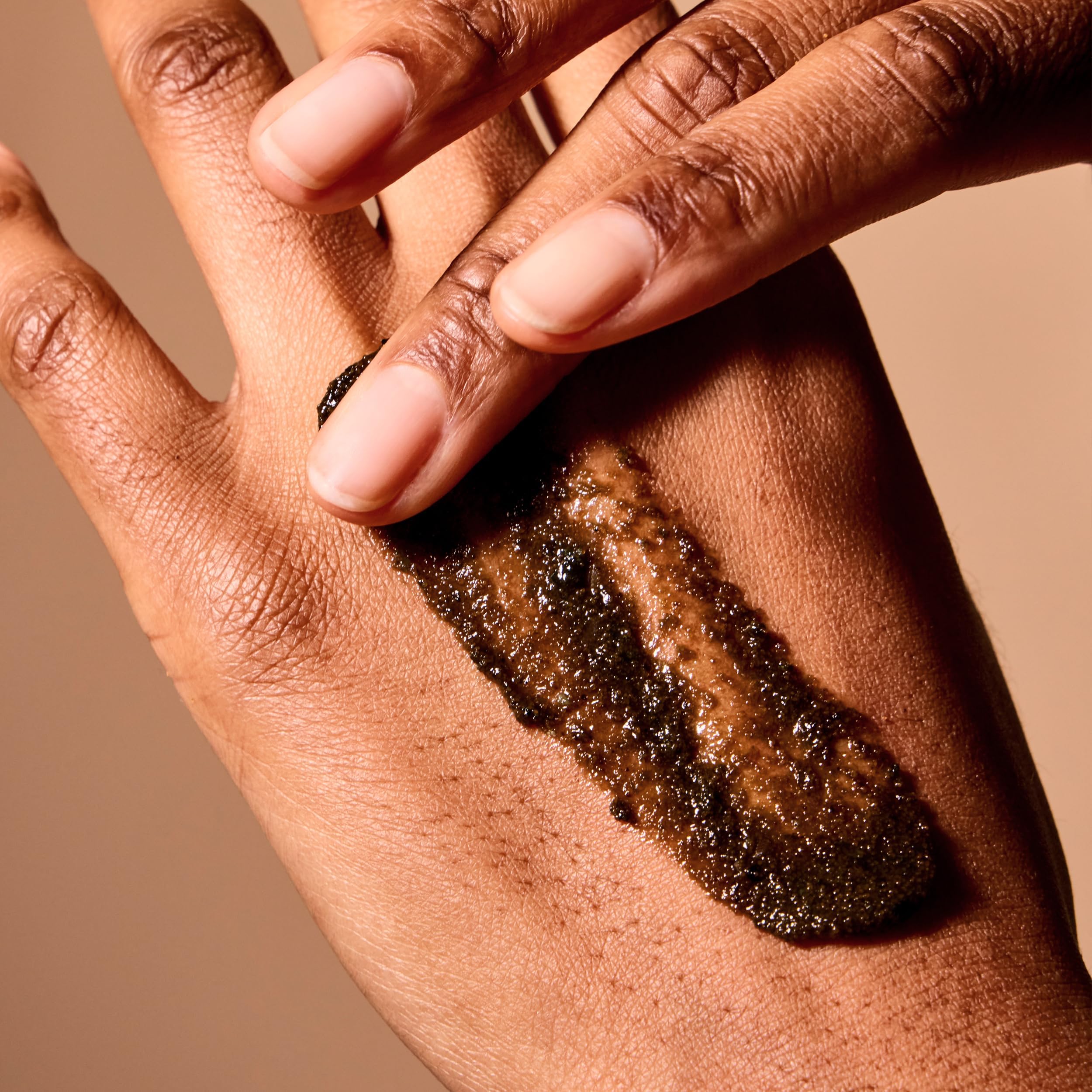 Acure Brightening Body Scrub clay-niacinamide detail highlighting texture refinement.