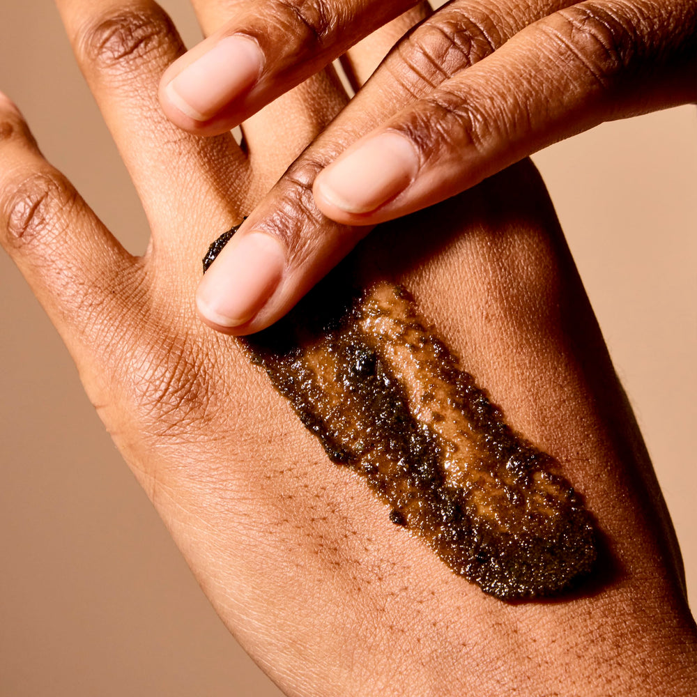 Acure Brightening Body Scrub clay-niacinamide detail highlighting texture refinement.