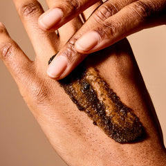 Acure Brightening Body Scrub clay-niacinamide detail highlighting texture refinement.