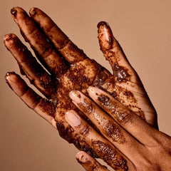 Acure Brightening Body Scrub label close-up emphasizing vegan, clean formula.