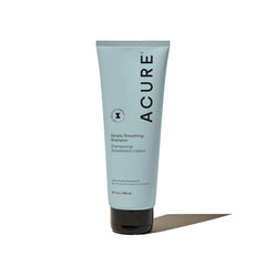 Acure Simply Smoothing Shampoo bottle closeup with frizz control for smooth hair.