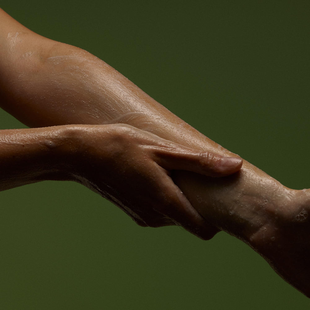 Applying Aesop Geranium Leaf Exfoliating Body Scrub on soaked skin.