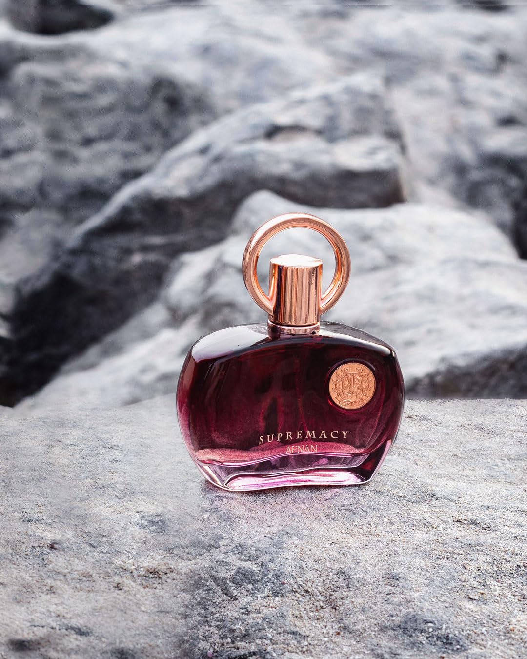 Hand holds Afnan Supremacy Purple bottle for on-the-go refinement.
