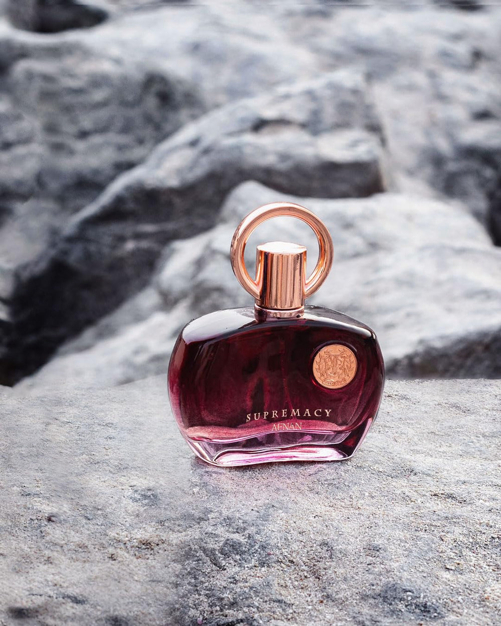 Hand holds Afnan Supremacy Purple bottle for on-the-go refinement.