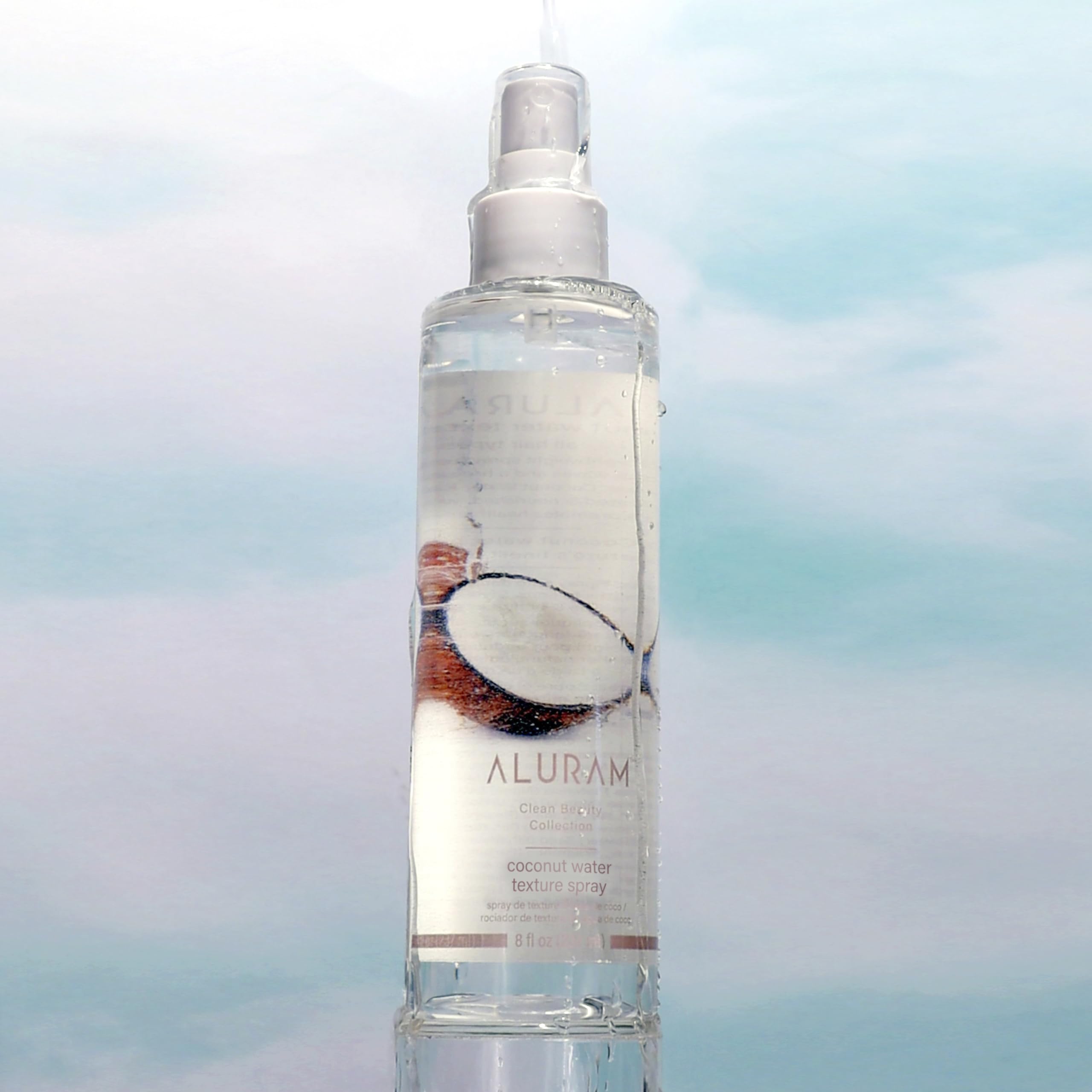 ALURAM Coconut Water Texture Spray on damp hair for hydrated, defined waves.