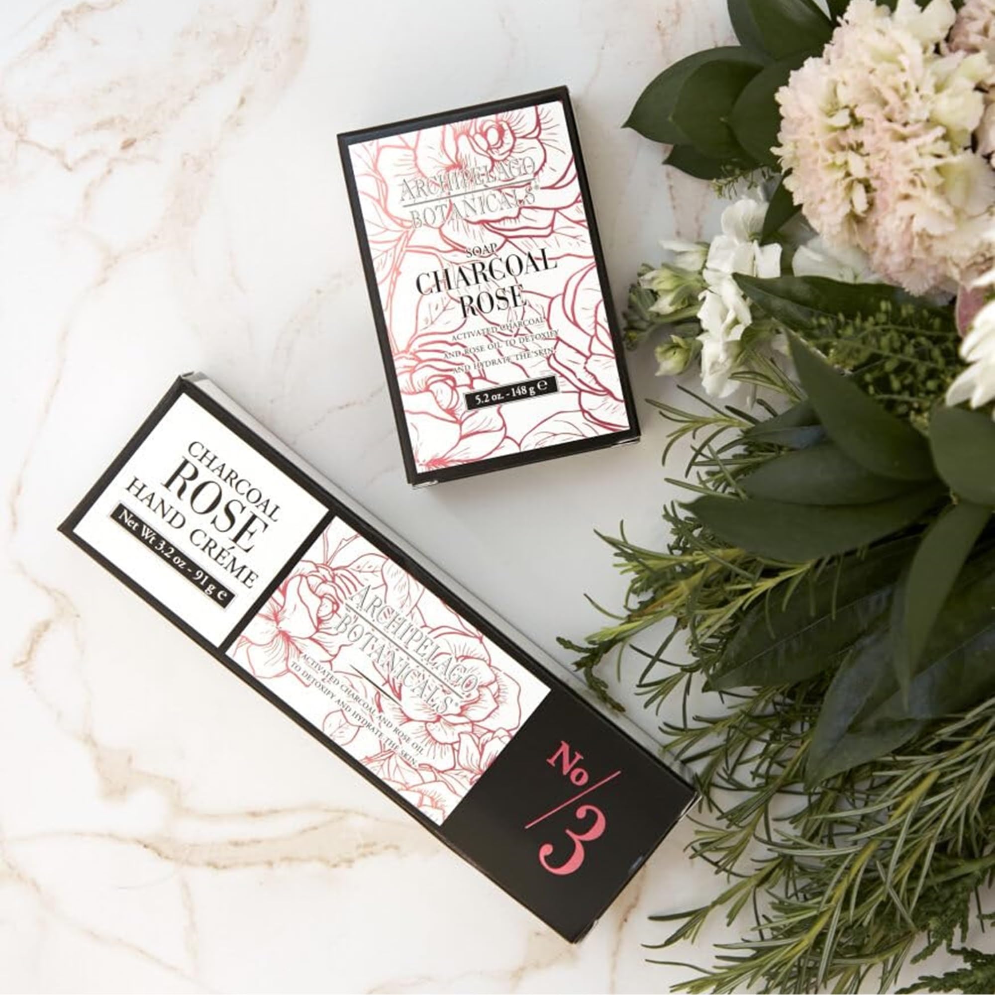 Archipelago Botanicals Charcoal Rose Hand Crème jar opened to reveal creamy formula.