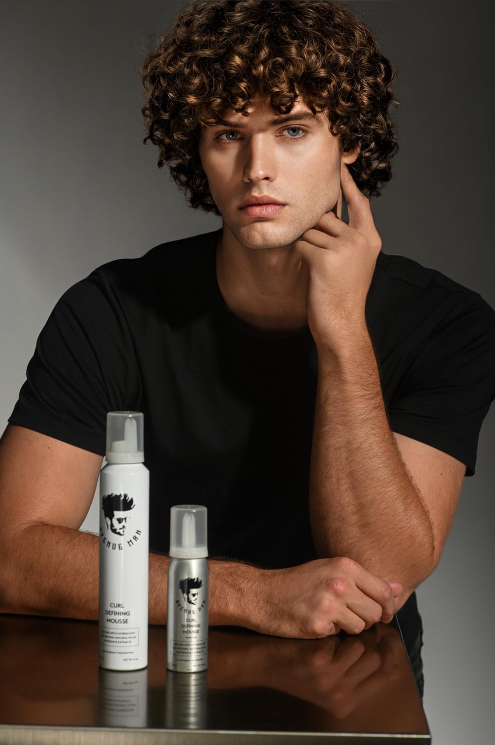 Applying Avenue Man mousse to damp curls for natural definition.