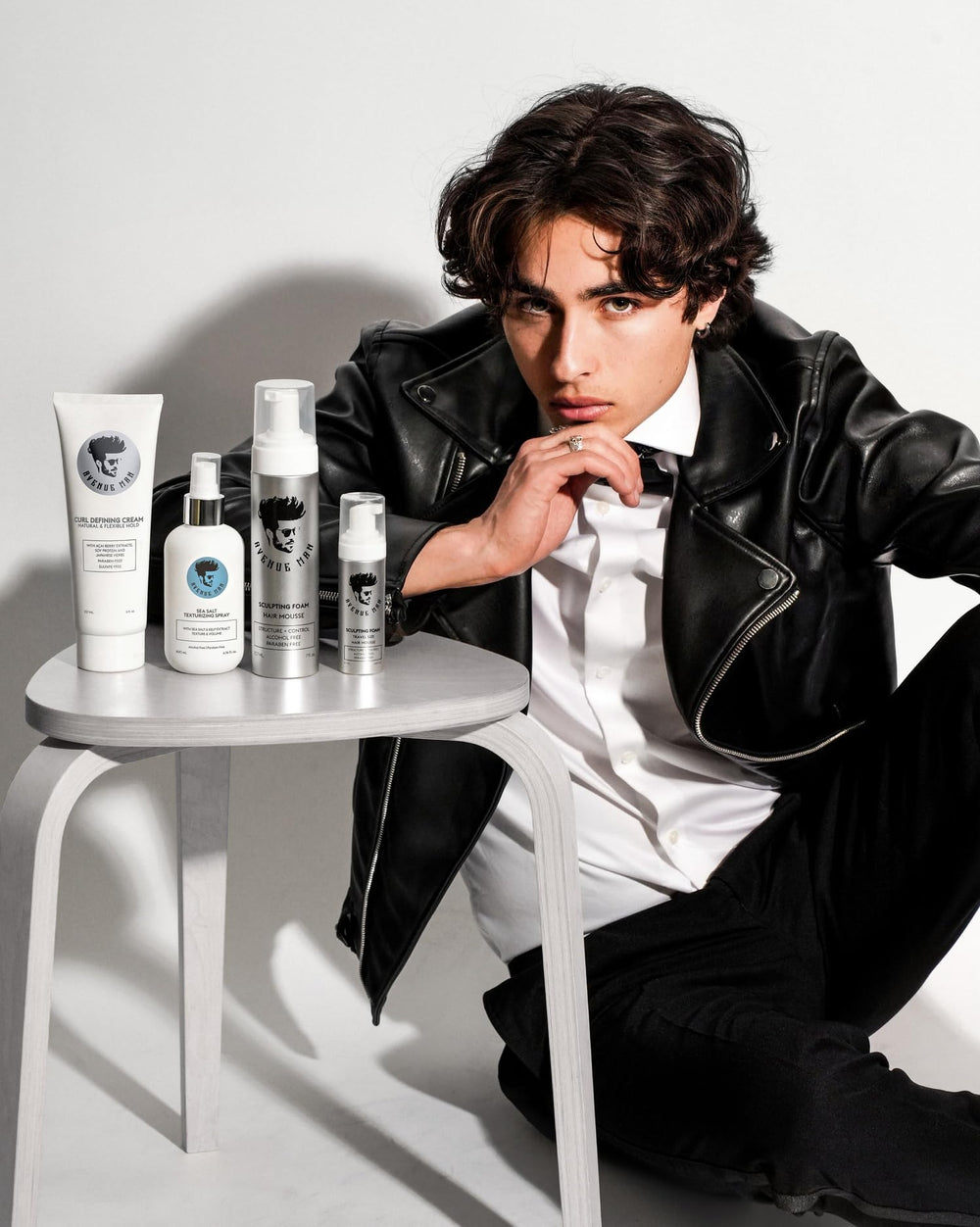 Avenue Man applying spray while styling a casual hairstyle.