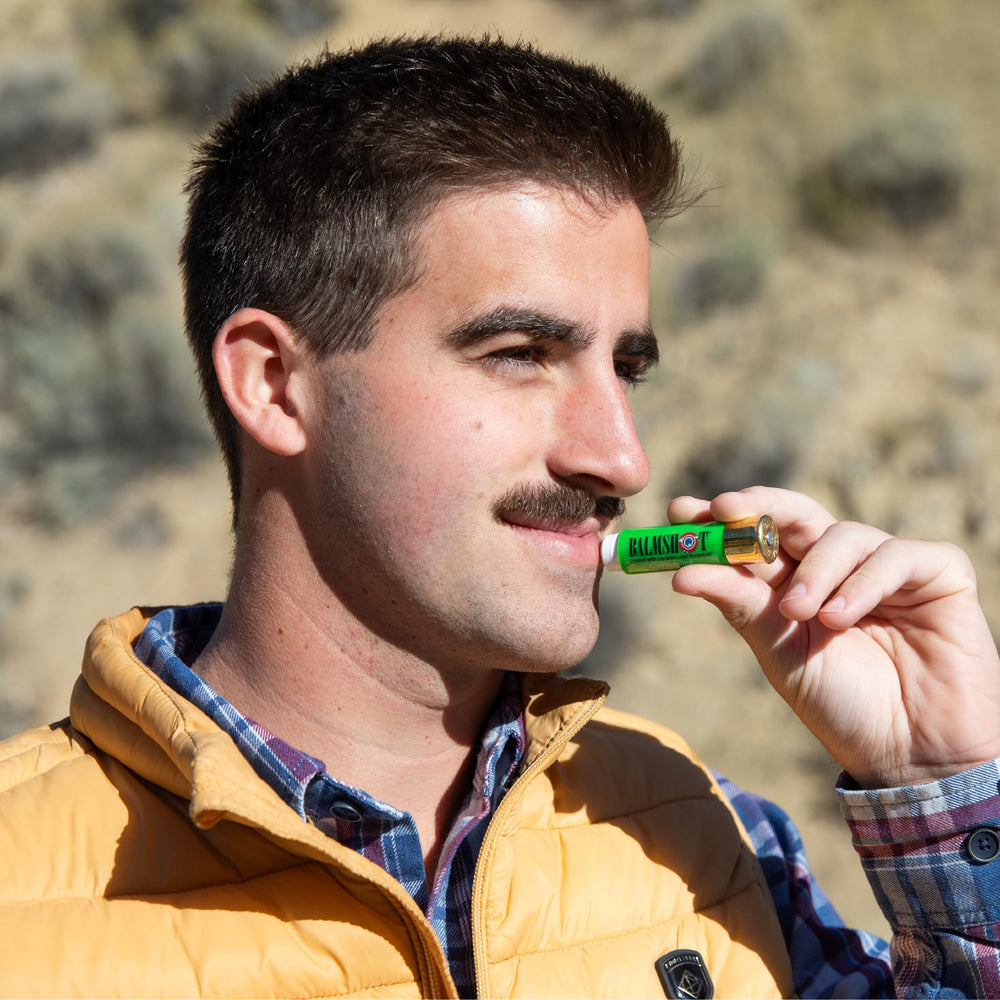 Balmshot lip balm with natural ingredients on counter.