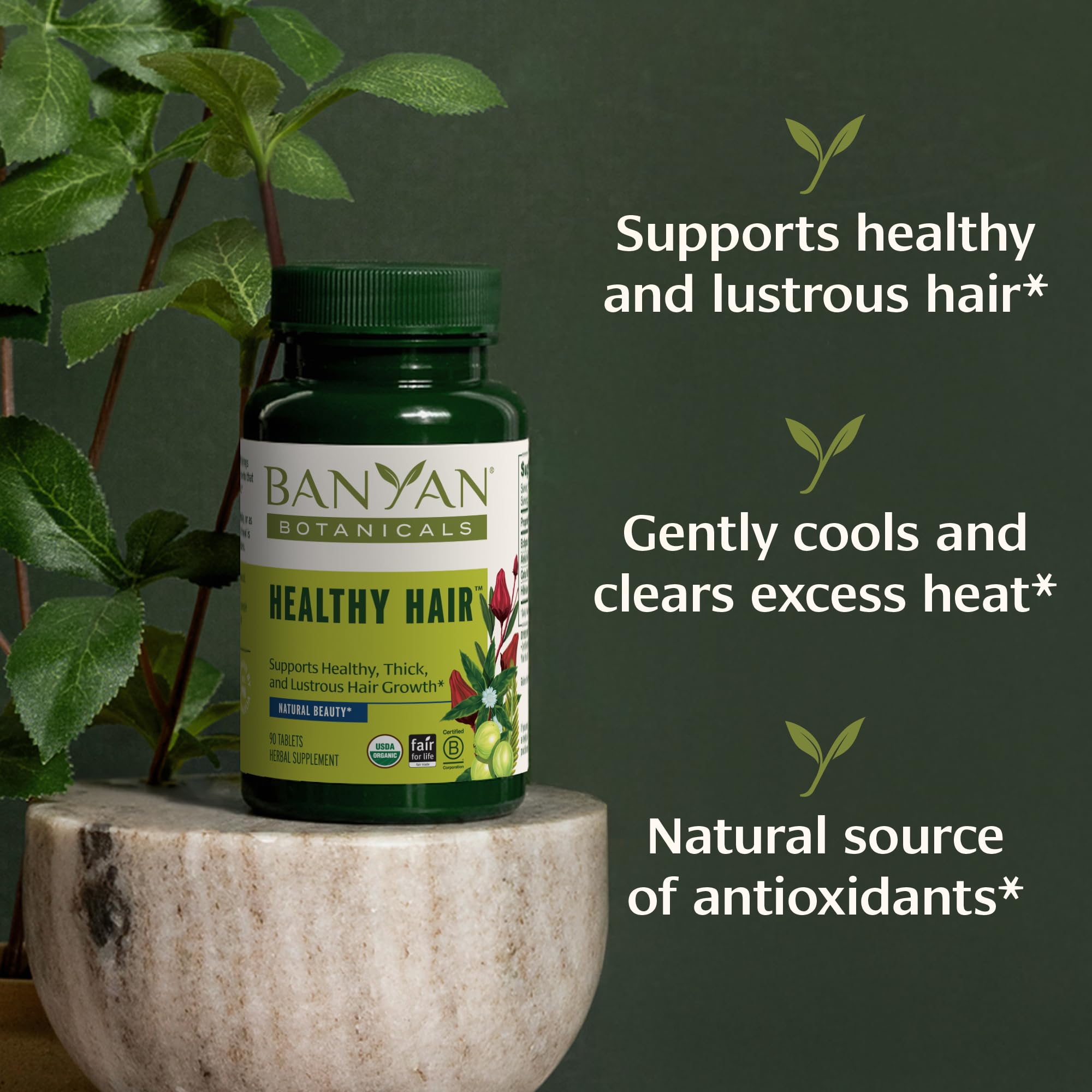 Banyan Botanicals Healthy Hair Tablets capsules closeup highlighting amla and bhringaraj ingredients.